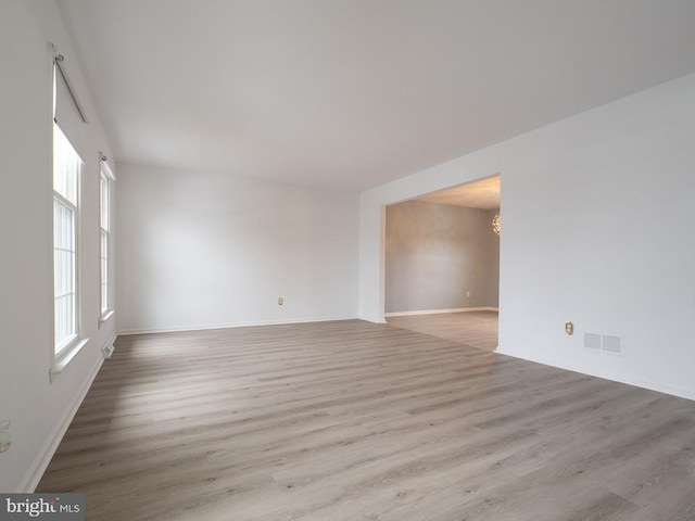 unfurnished room featuring light hardwood / wood-style floors and a notable chandelier