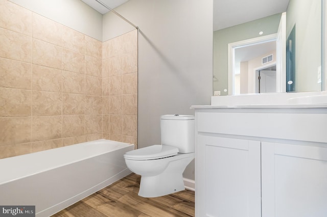 full bathroom featuring wood-type flooring, shower / tub combination, vanity, and toilet