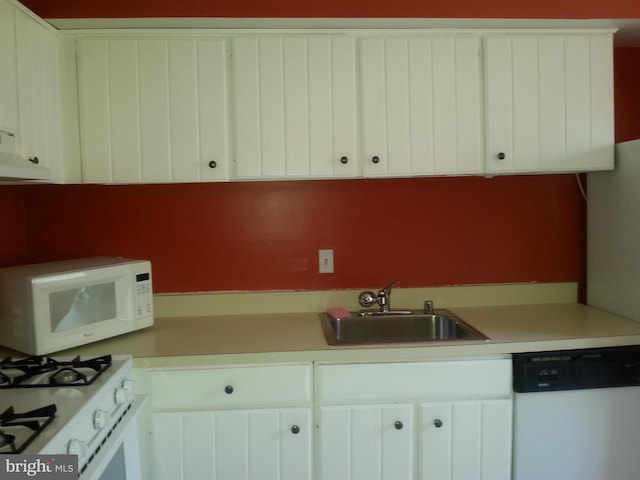 kitchen featuring white cabinetry, sink, and white appliances