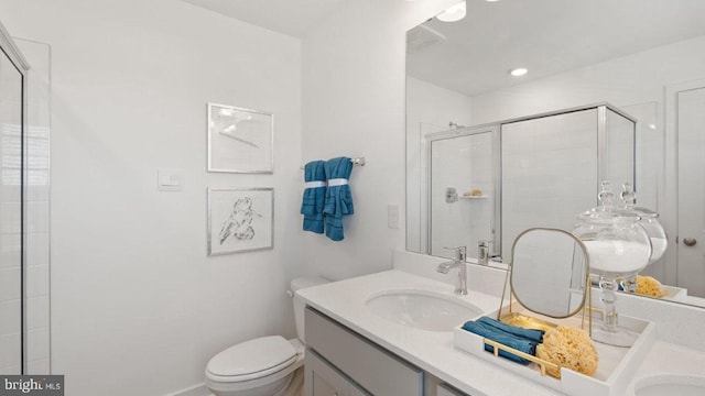 bathroom with walk in shower, vanity, and toilet