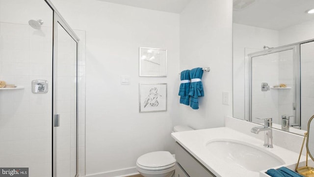 bathroom with toilet, vanity, and an enclosed shower