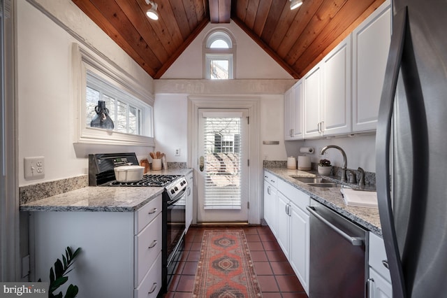 kitchen with wooden ceiling, stainless steel appliances, dark tile patterned flooring, a sink, and white cabinetry