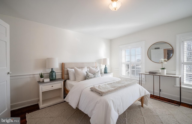 bedroom with baseboards and wood finished floors