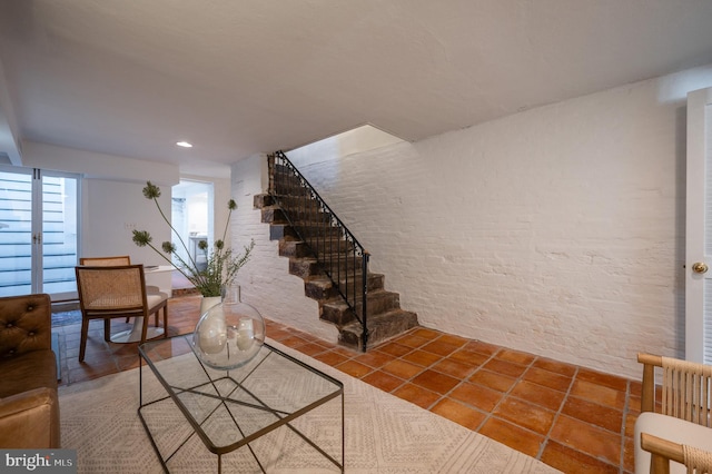 stairs featuring brick wall and tile patterned floors