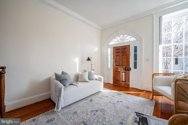 interior space featuring baseboards, crown molding, and wood finished floors