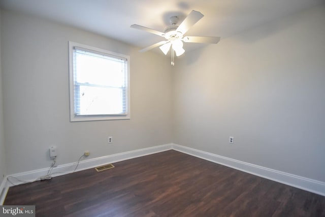 spare room featuring dark wood-type flooring and ceiling fan