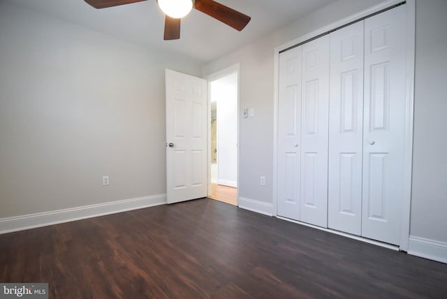 unfurnished bedroom featuring dark wood-type flooring, ceiling fan, and a closet