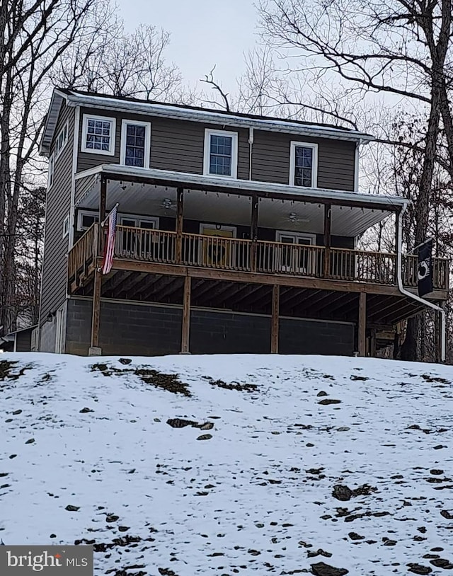 snow covered house featuring a deck