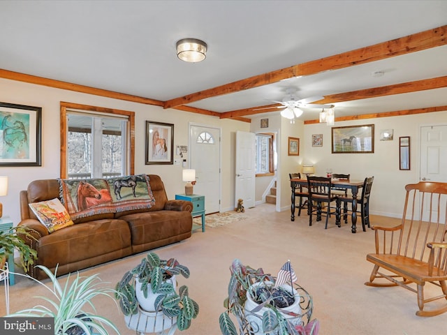 carpeted living room with beamed ceiling