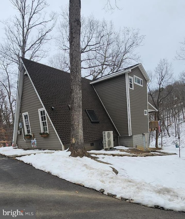 view of snow covered exterior with cooling unit