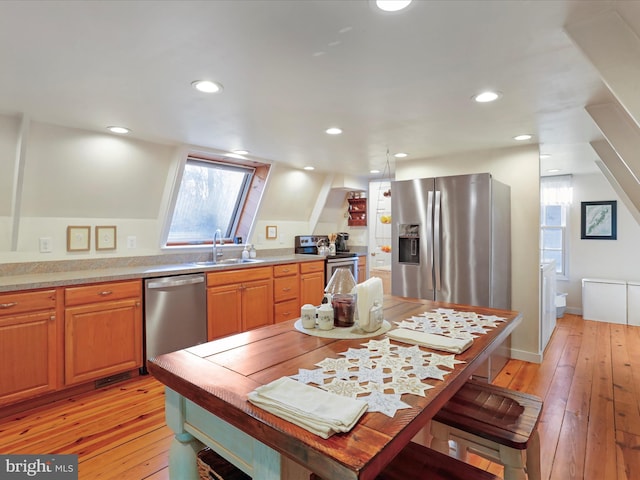 kitchen featuring stainless steel appliances, sink, and light hardwood / wood-style floors