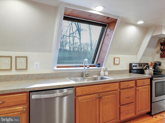 kitchen with stainless steel appliances, sink, and light wood-type flooring