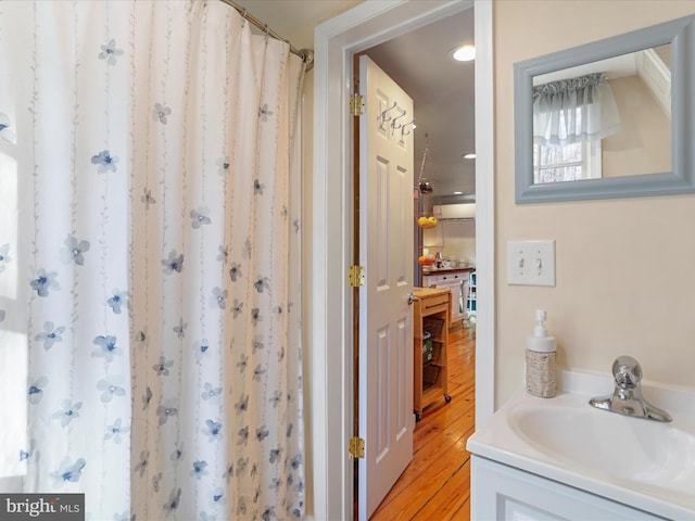 bathroom featuring walk in shower, wood-type flooring, and vanity