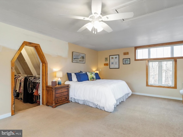 carpeted bedroom with ceiling fan, a spacious closet, and a closet