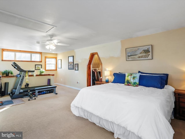 bedroom featuring ceiling fan, a walk in closet, a closet, and light carpet