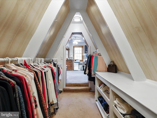 spacious closet featuring vaulted ceiling and light colored carpet