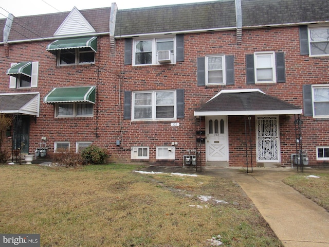 townhome / multi-family property featuring cooling unit and a front lawn