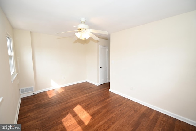 empty room with ceiling fan and dark hardwood / wood-style flooring