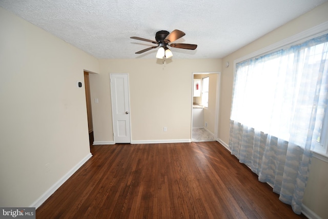 empty room featuring ceiling fan, a textured ceiling, and dark hardwood / wood-style floors