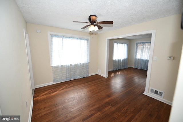 unfurnished room with ceiling fan, dark wood-type flooring, and a textured ceiling