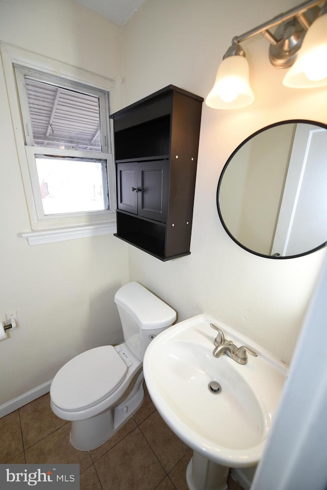 bathroom with sink, toilet, and tile patterned flooring