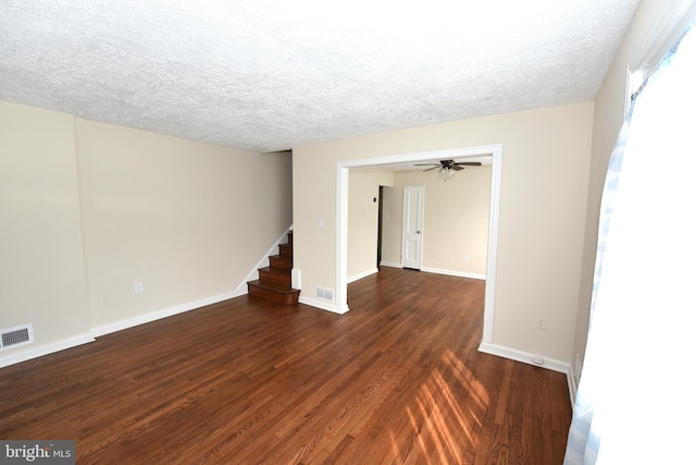 empty room featuring a textured ceiling, ceiling fan, and dark hardwood / wood-style flooring