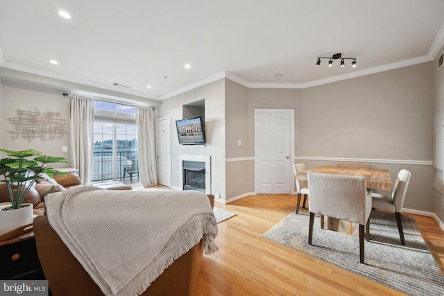 bedroom featuring ornamental molding, track lighting, access to exterior, and light hardwood / wood-style flooring