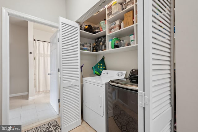 clothes washing area featuring separate washer and dryer and light tile patterned floors