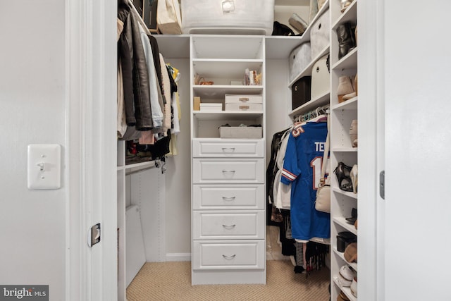 walk in closet featuring light colored carpet