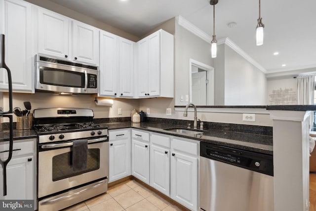 kitchen with white cabinetry, stainless steel appliances, sink, and pendant lighting