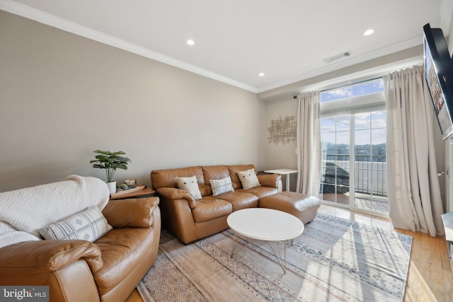 living room featuring crown molding and light hardwood / wood-style floors