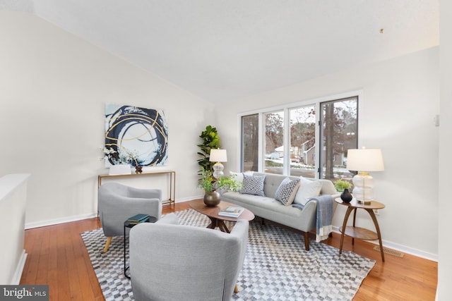 living room featuring lofted ceiling and hardwood / wood-style floors