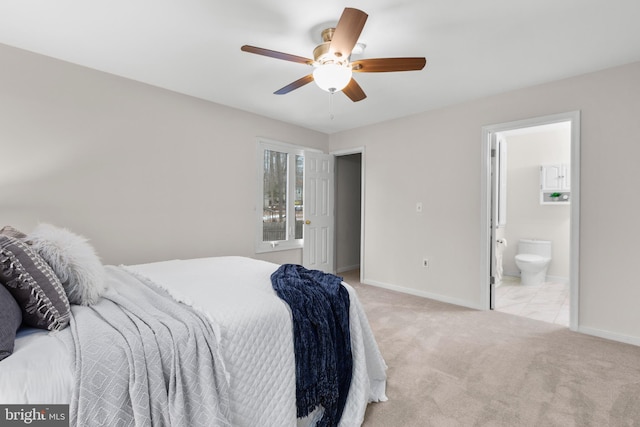 bedroom with ensuite bathroom, ceiling fan, and light carpet