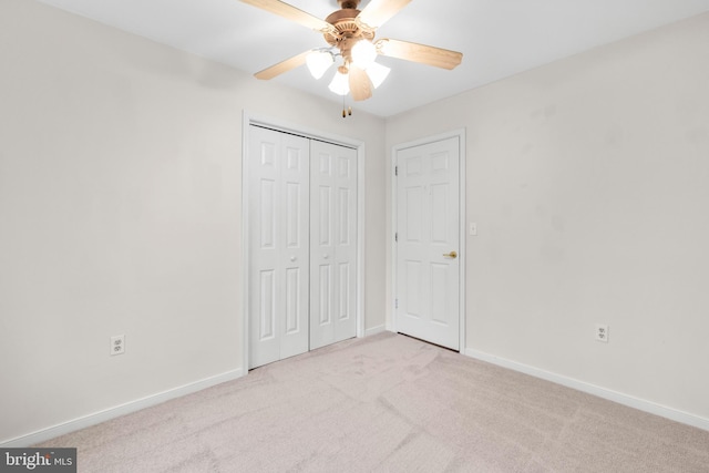 unfurnished bedroom featuring ceiling fan, a closet, and light carpet