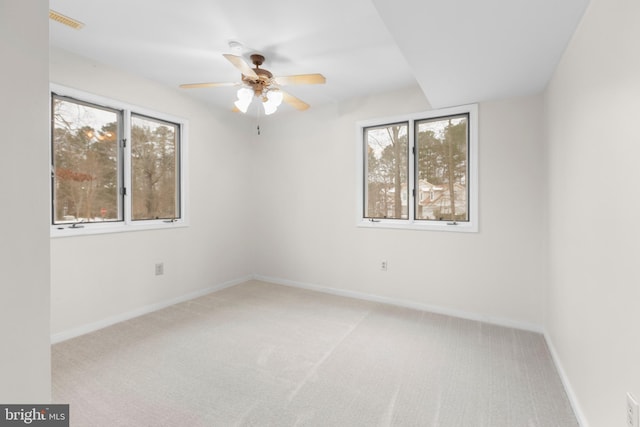 carpeted spare room with ceiling fan