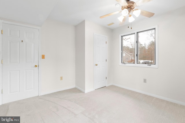 carpeted spare room with ceiling fan