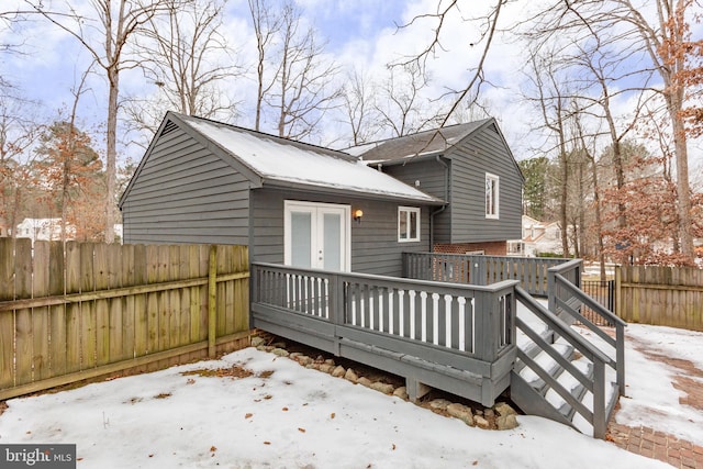 snow covered rear of property featuring a wooden deck