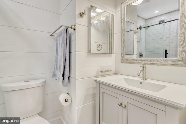 bathroom with a shower with door, toilet, and vanity