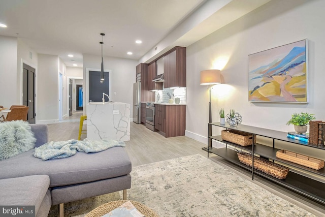 living room with sink and light hardwood / wood-style floors