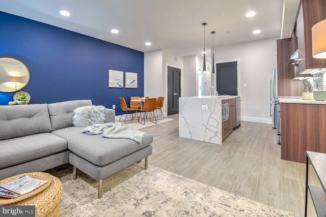 living room featuring sink and light hardwood / wood-style floors