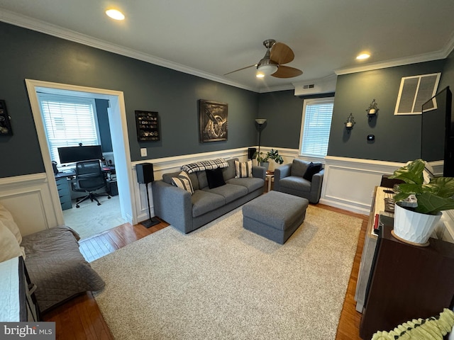 living room featuring ceiling fan, ornamental molding, and light hardwood / wood-style floors