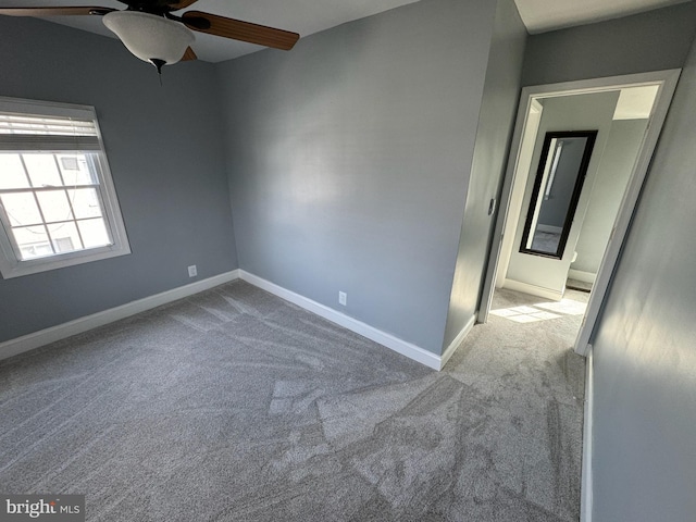 spare room with ceiling fan and light colored carpet