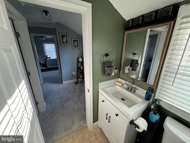 bathroom with vanity, vaulted ceiling, tile patterned floors, and toilet