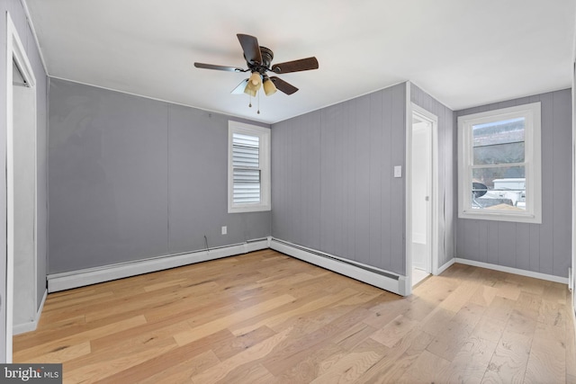 bonus room with ceiling fan, a baseboard heating unit, and light hardwood / wood-style flooring