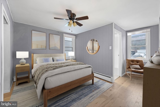 bedroom featuring ceiling fan, light hardwood / wood-style flooring, and a baseboard radiator