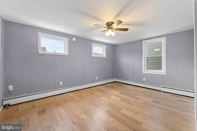 unfurnished room featuring a baseboard heating unit, ceiling fan, and light hardwood / wood-style floors