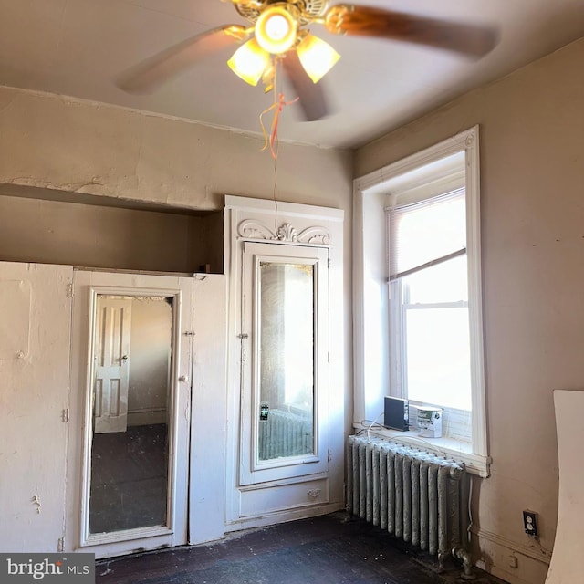 interior space with radiator heating unit and ceiling fan