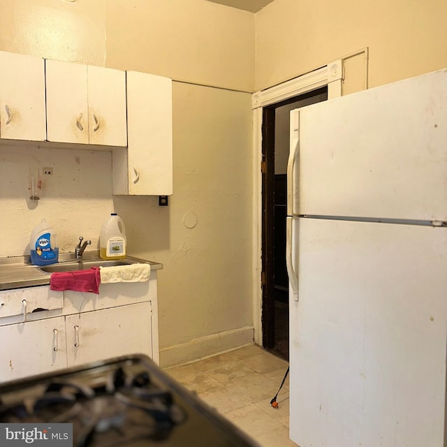 kitchen featuring white cabinetry, sink, and white refrigerator