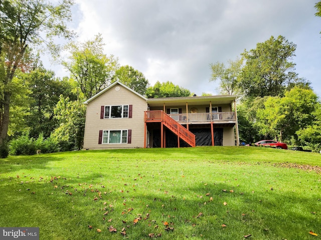 back of property with a wooden deck and a lawn