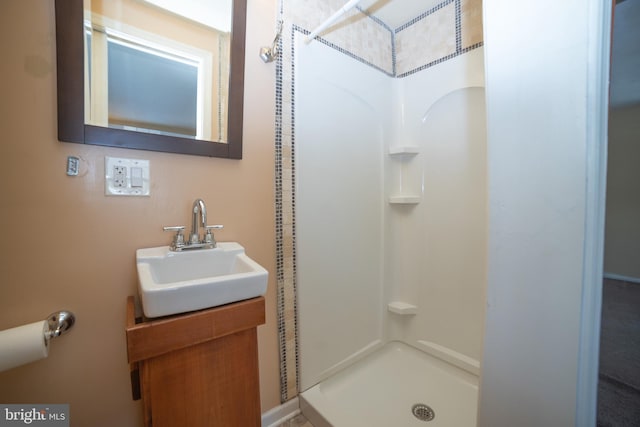 bathroom featuring walk in shower and vanity